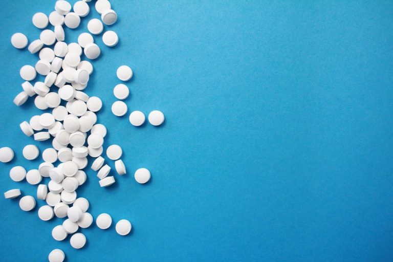 pills in a spread out pile on blue background
